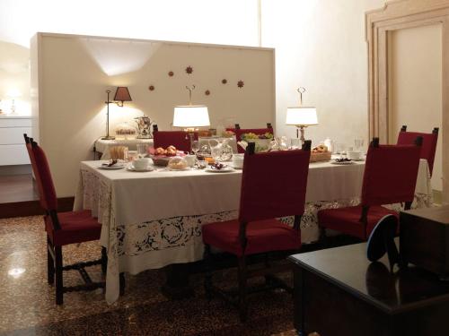 博洛尼亚Antica Casa Zucchini B&B的一间用餐室,配有白色桌子和红色椅子