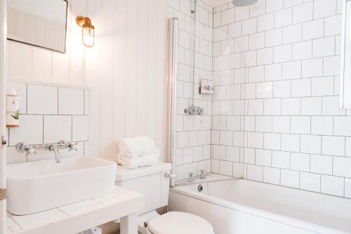 OdihamBel and The Dragon-Odiham的白色的浴室设有水槽、卫生间和浴缸。
