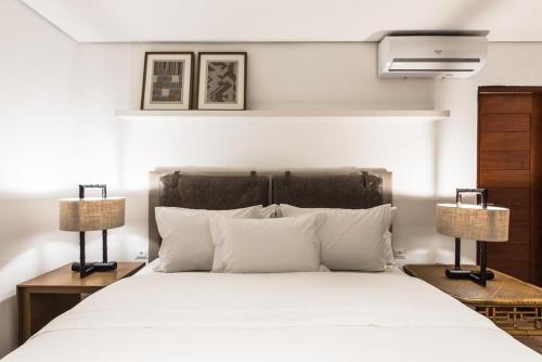 费尔南多 - 迪诺罗尼亚Casa Amarela的一间卧室配有一张带两盏灯的大型白色床。