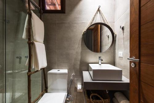 费尔南多 - 迪诺罗尼亚Casa Amarela的一间带水槽、卫生间和镜子的浴室