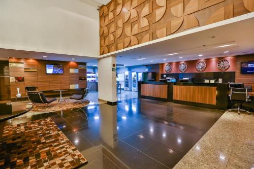 戈亚尼亚SJ Premium Hotels By Atlantica的酒店大堂设有前台和椅子