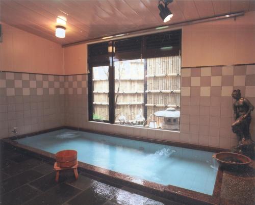 伊东Hinodeya的一间设有雕像的房间,里面有一个大型水池