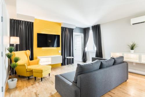 蒙克顿Capitol Robinson by Bower Boutique Hotels的带沙发和黄色椅子的客厅