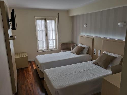 布拉加多拉住宅酒店的酒店客房设有两张床和窗户。