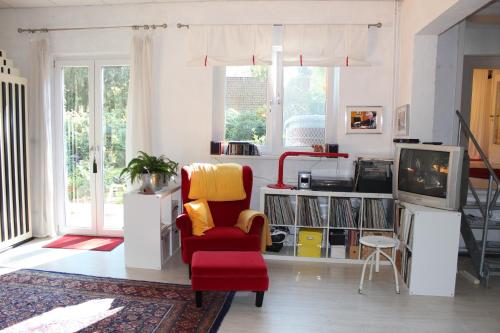 施内沃丁根Bed & Breakfast Wesseloh的客厅配有红色椅子和电视