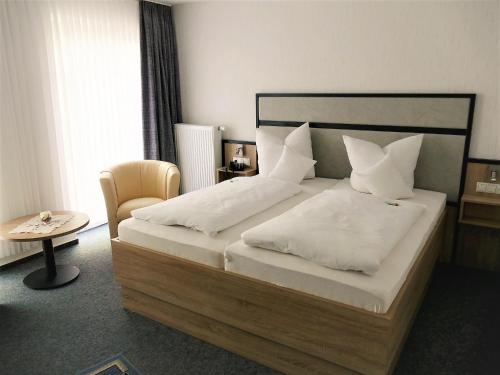 克洛彭堡Hotel Diekgerdes, Komfortzimmer的卧室配有一张带白色床单和枕头的大床。
