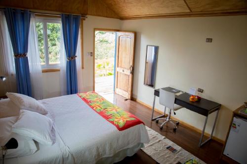 安加罗阿塔奥拉雅酒店的一间卧室配有一张床、一张书桌和一个窗户。