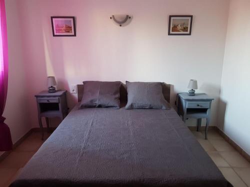 圣马迪拉莫Appartement de l'olivier的一间卧室配有一张大床和两张桌子
