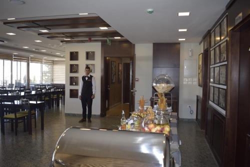 安曼沙姆斯艾尔韦布德公寓式酒店的身着西装的人站在带桌子的房间