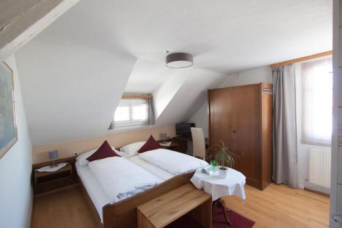 洛豪Wellenhof Bodensee的一间卧室配有一张大床和一张桌子