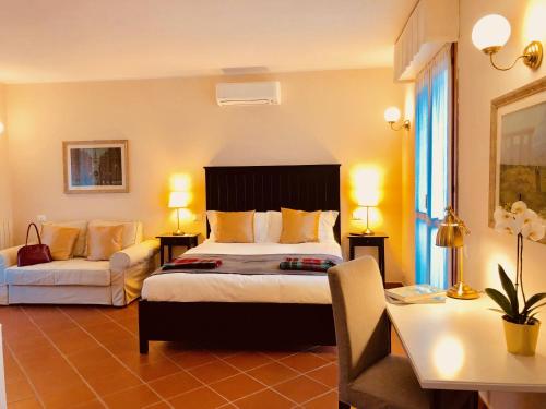 比萨Casa Ciampi Locazione Turistica的酒店客房配有一张床、一张沙发和一张书桌。