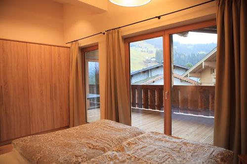 平茨高谷地霍勒尔斯巴赫Kitzbuheler Alpen Penthouse Hollersbach的一间卧室设有一张床和一个大窗户