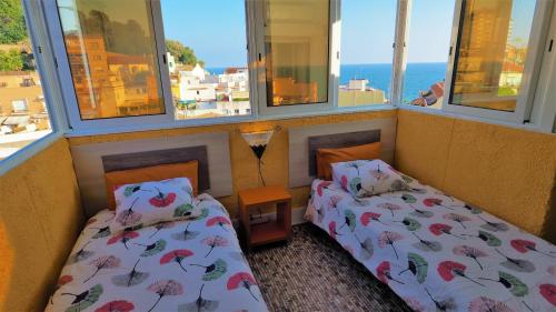 蒙特加特克莱尔海景海滩公寓的带窗户的客房内设有两张床的房间