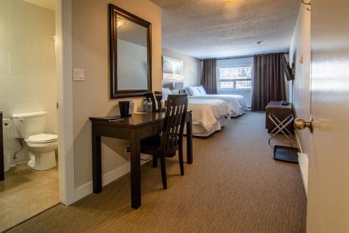 乔治王子城Northwood Plaza Hotel的酒店客房设有一张床、一张书桌和一间浴室。
