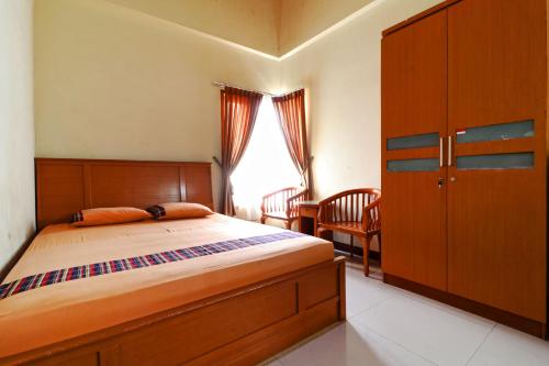 贝克西Bedur Homestay Syariah的一间卧室配有一张床、一张书桌和一个窗户。