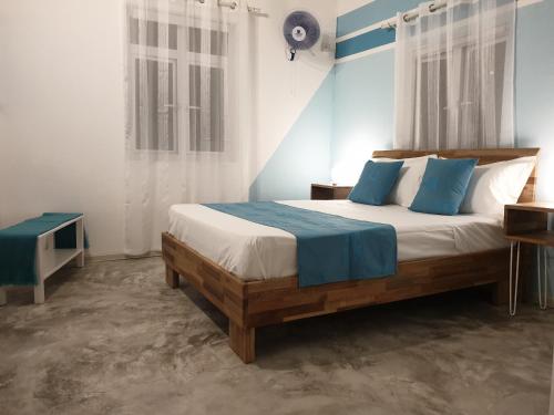 托舵道斯Casa Frangipani Mauritius的一间卧室配有一张带蓝色和白色枕头的床