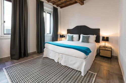 佛罗伦萨Globus Urban Hotel的一间卧室配有一张带蓝白色枕头的大床