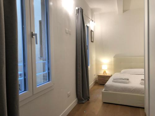 佛罗伦萨San Frediano Apartment的一间卧室设有一张床和一个大窗户