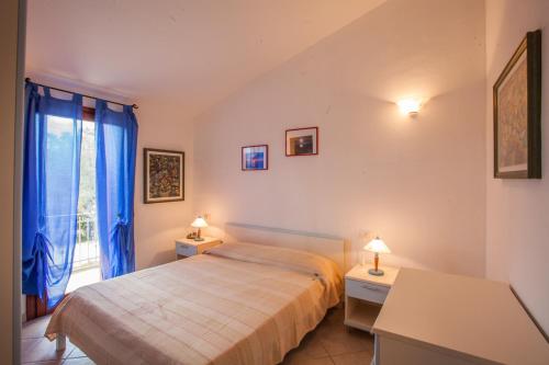 奥尔比亚Maestrale Flat - Klodge的一间卧室配有床和蓝色窗帘的窗户