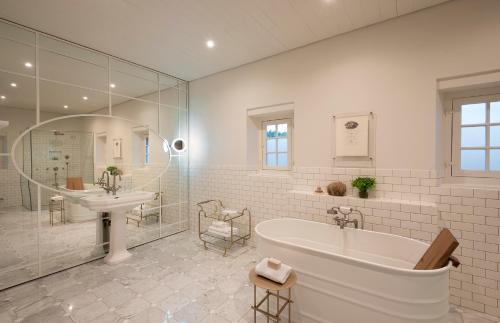 Simondium巴比隆塔楼酒店的白色的浴室设有浴缸和水槽。