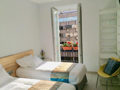 马德里Hostal Palacio Luna的一间卧室设有两张床和一个植物窗户