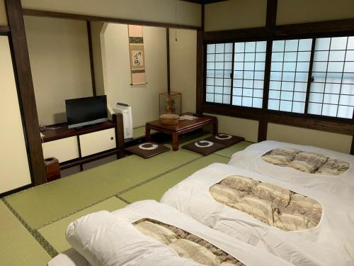高山村山日式旅馆的一间设有两张床和电视的房间