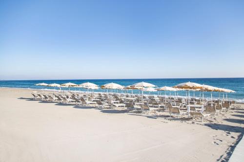 曼达托里乔码头天堂村酒店的海滩上的一组椅子和遮阳伞
