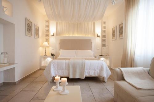 卢切拉Relais in Contrada的白色卧室配有床和沙发