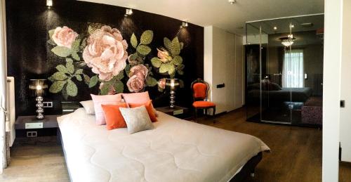 TuraidaBoutique Hotel Bersas的卧室配有带粉红色枕头的大型白色床
