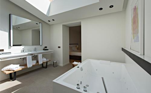 坎塔卢普斯Hotel Can Xiquet的带浴缸、水槽和镜子的浴室