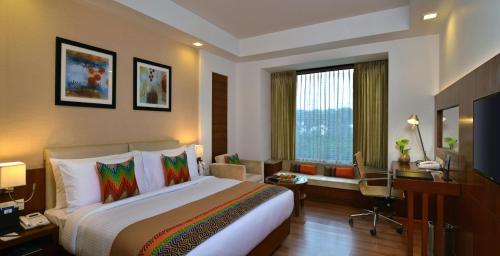 BhiwadiFortune Park Orange, Sidhrawali - Member ITC's Hotel Group的酒店客房设有一张大床和一张书桌。