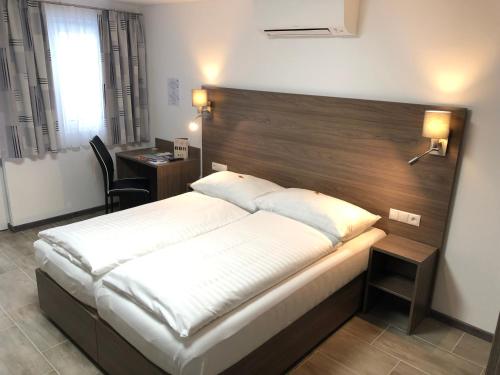 维也纳克尼格酒店的一间卧室配有一张大床和木制床头板