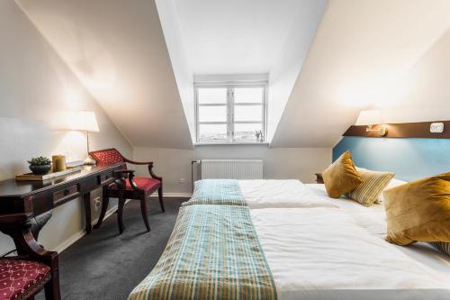 德拉厄Copenhagen Airport Hotel的一间卧室配有一张大床和一张书桌