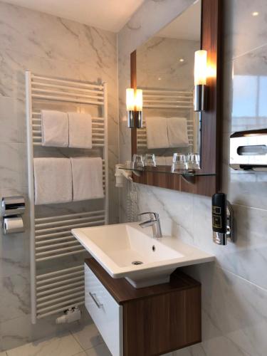维也纳克尼格酒店的白色的浴室设有水槽和镜子