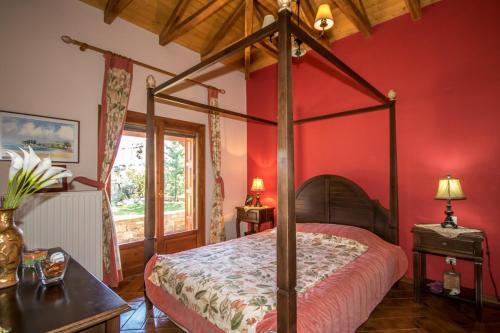 科罗皮Luxury Villa Helios的一间卧室设有天蓬床和红色墙壁
