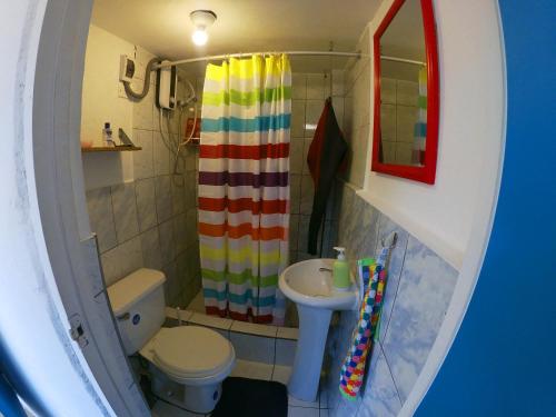 万查科Urcia Surf House的一间带彩虹浴帘和水槽的浴室