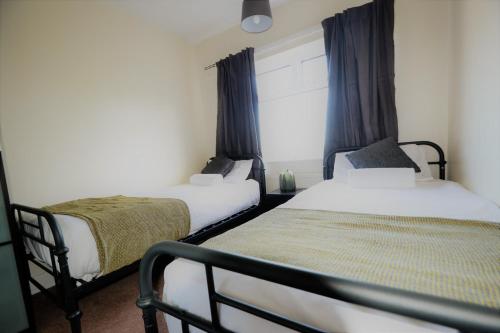 特尔福德14 Castle View Red Lake的一间卧室设有两张床和窗户。