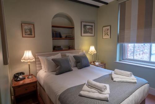 韦尔斯White Hart Inn的一间卧室配有一张大床和毛巾