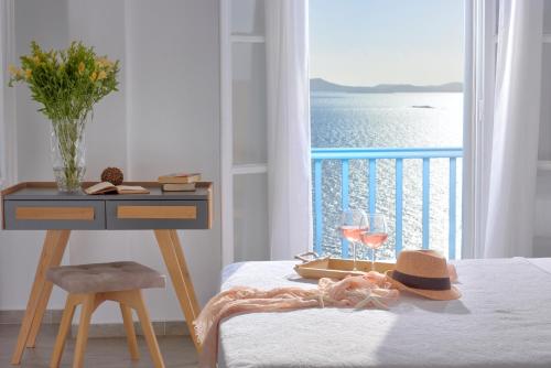 圣斯特凡诺斯Amelie Suites的一间带桌子的卧室,享有海景