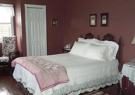Pubnico雅阁海滩住宿加早餐旅馆的一间卧室配有一张粉红色墙壁的床
