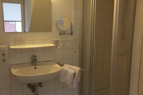 梅尔斯堡Hotel Bacchus Wine & Bites的白色的浴室设有水槽和淋浴。