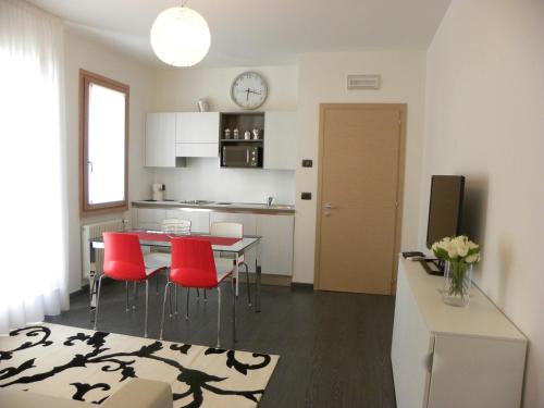 梅斯特丹汀威尼斯公寓，的厨房以及带桌子和红色椅子的用餐室。