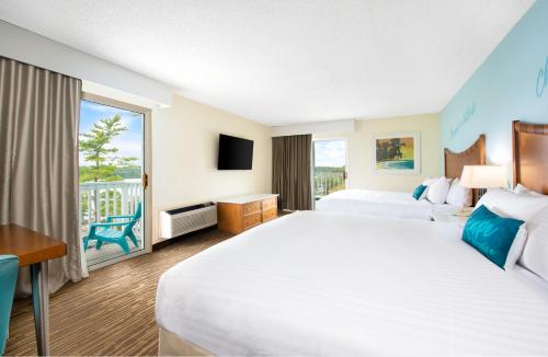 欧塞奇比奇Margaritaville Lake Resort Lake of the Ozarks的酒店客房设有一张大床和一个阳台。