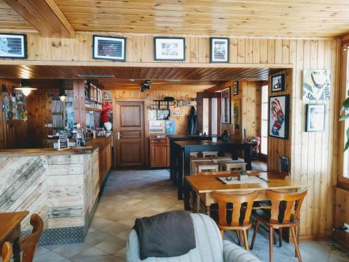 La GouilleHôtel Pension du Lac Bleu的餐厅拥有木墙和木桌及椅子