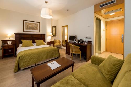 萨拉曼卡Itaca Salamanca by Soho Boutique的酒店客房配有一张床、一张书桌和一张沙发。