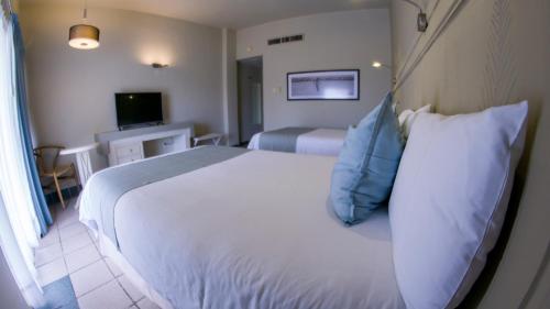 马德罗城玛伊瓦米瑞玛塔匹克酒店及俱乐部的卧室配有带蓝色枕头的大型白色床