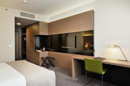 卢布尔雅那卢布尔雅那丽笙皇宫酒店的一间带一张床和一张书桌的卧室和一间厨房