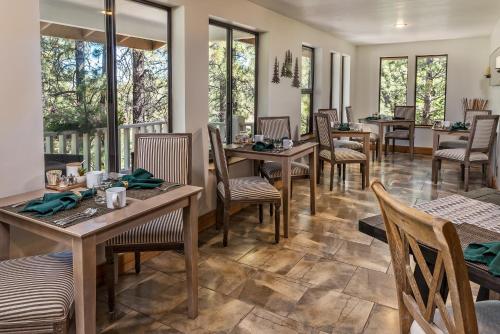 威廉姆斯谢里登旅馆-仅限成人住宿的餐厅设有木桌、椅子和窗户。