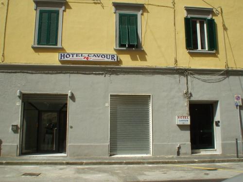 利沃诺Albergo Cavour SELF CHECK-IN的一座有两扇门的建筑,上面有标志