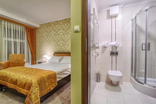 比亚韦斯托克桑塔纳酒店的一间卧室配有一张床,浴室设有淋浴。